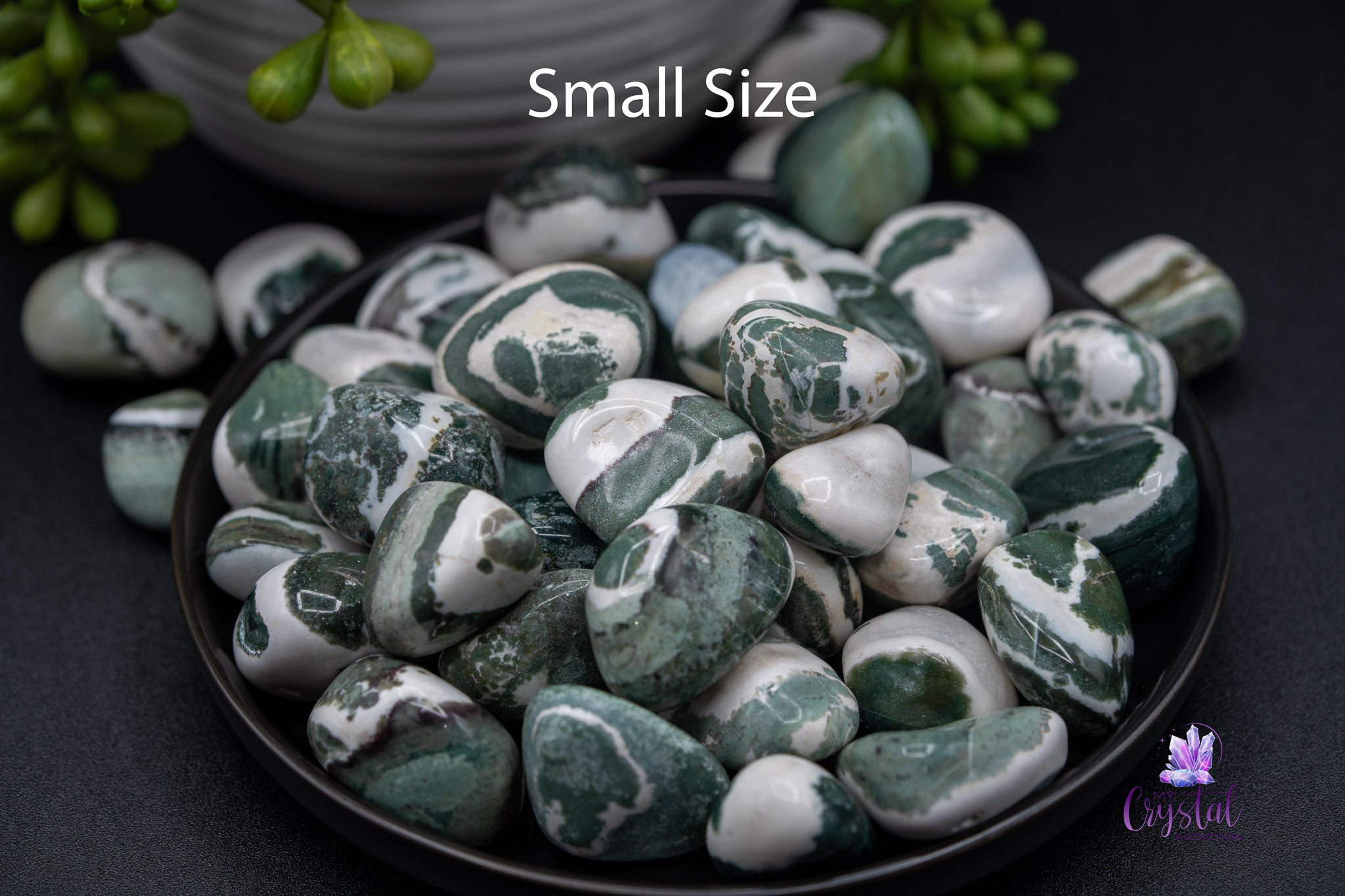 Small size tumbled green and white jasper stones in a black bowl, crystal decor