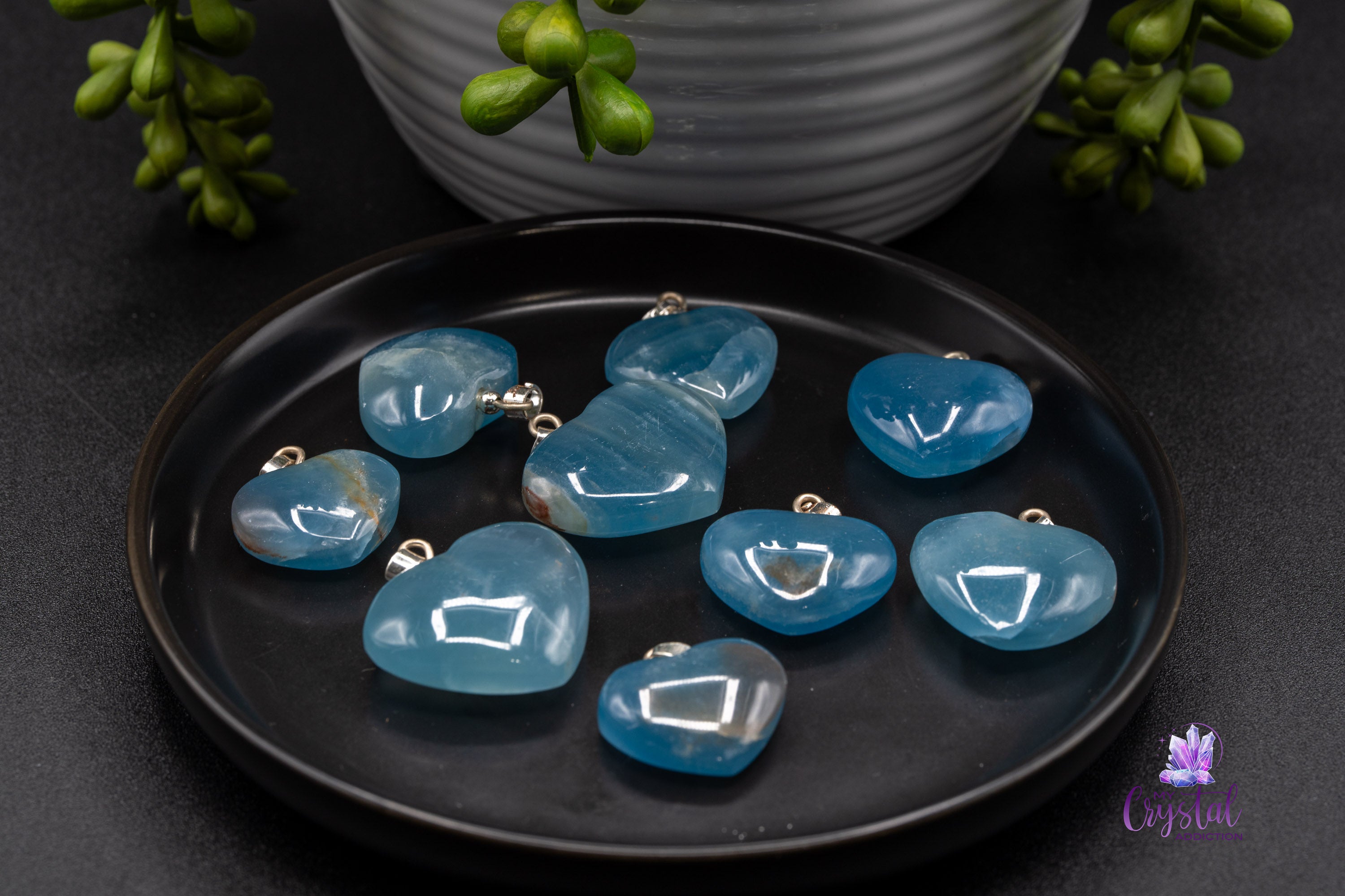 Blue calcite heart pendant on black plate