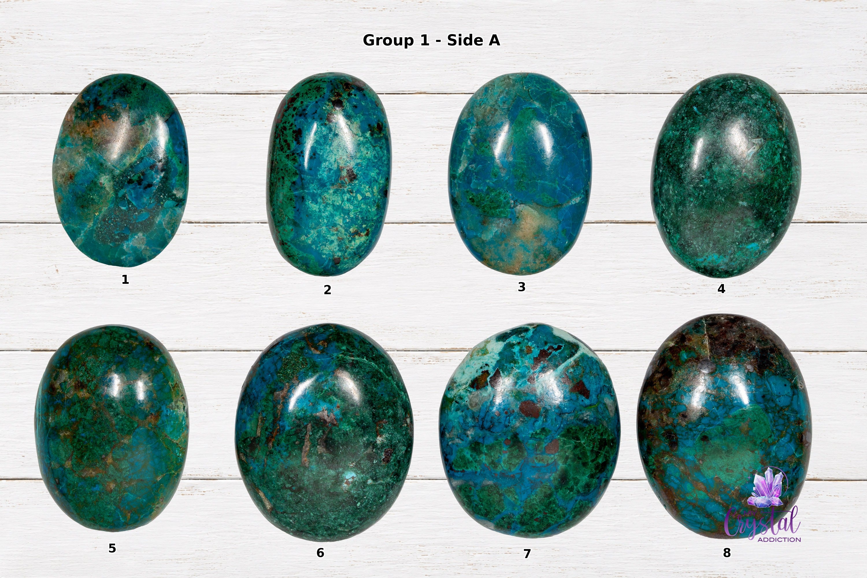 Front sides of chrysocolla palm stones numbered 1 through 8 on a white wood background.