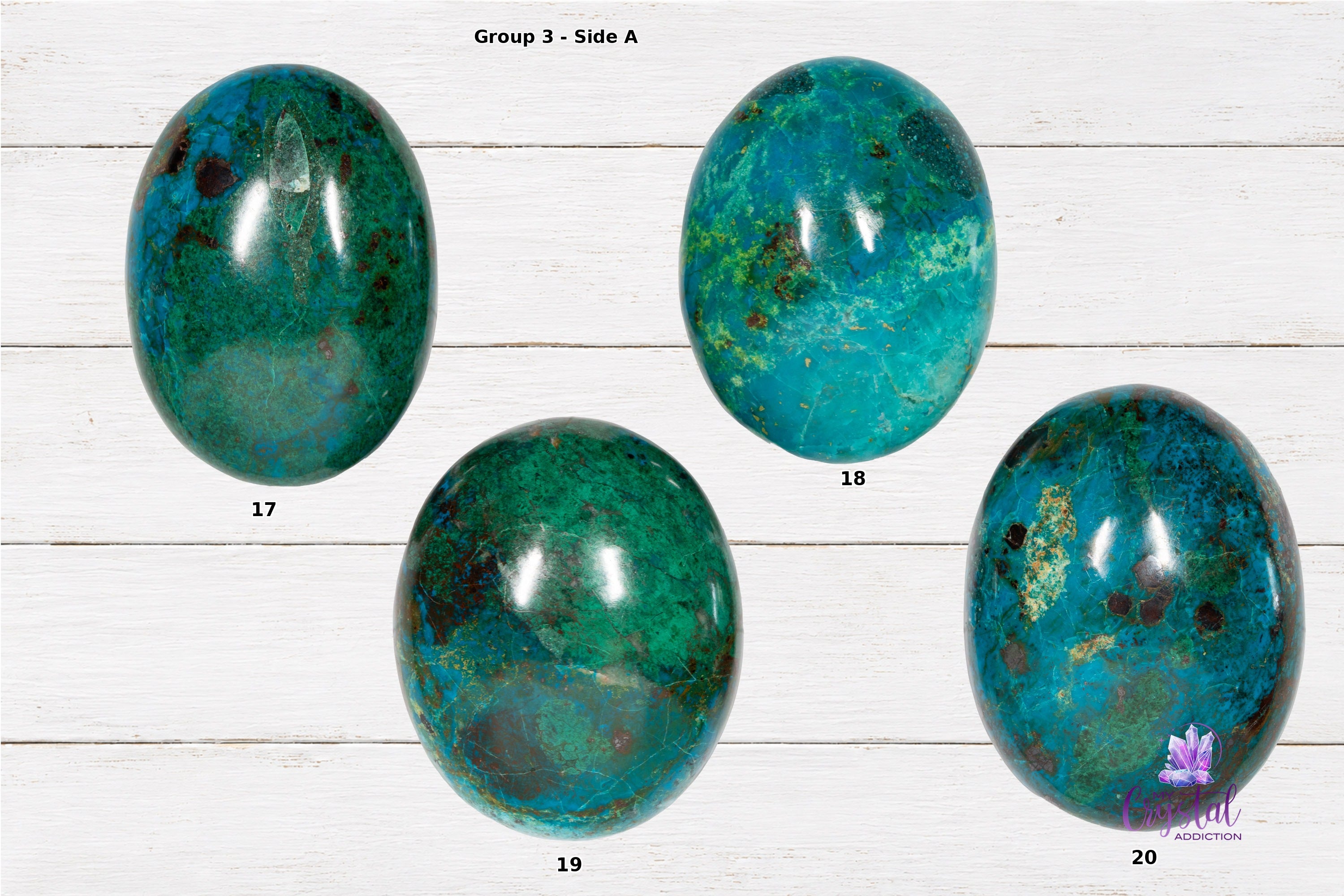 Front sides of chrysocolla palm stones numbered 17 through 20 on a white wood background.