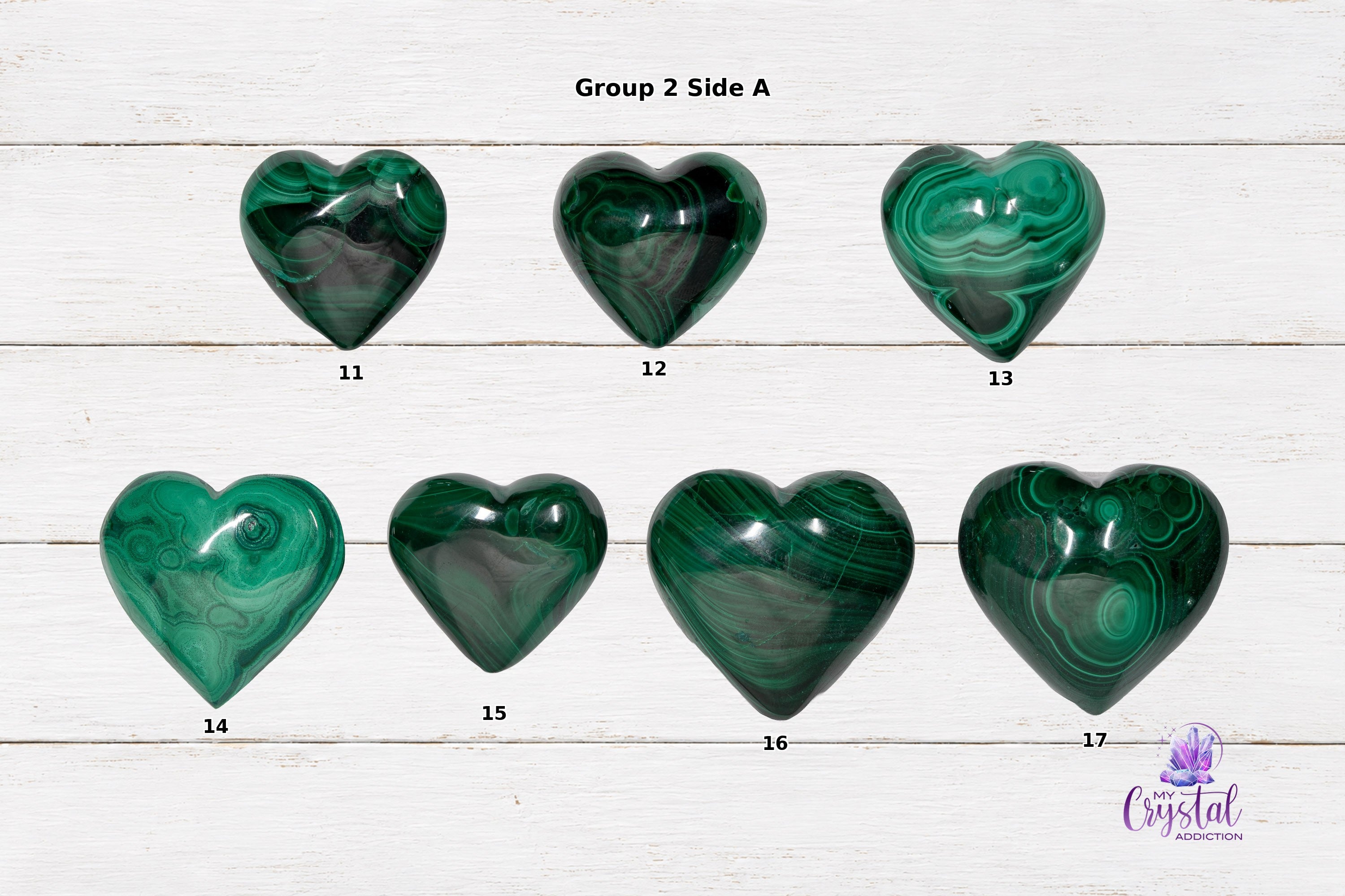 Front views of larger polished malachite heart carvings with dark and bright green swirls.